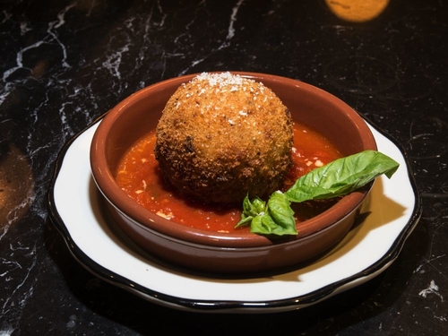 The happy hour meatball with red sauce and basil