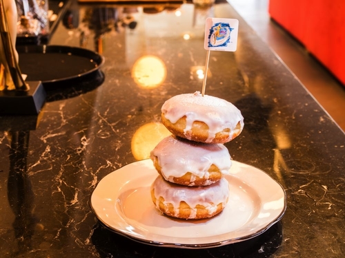 Three circular pastries stacked on top of each other with frosting and a Nittis flag on top