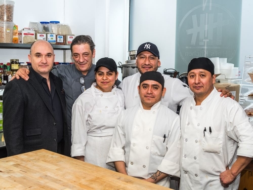 The owners of Nittis with the Chefs in the kitchen smiling together