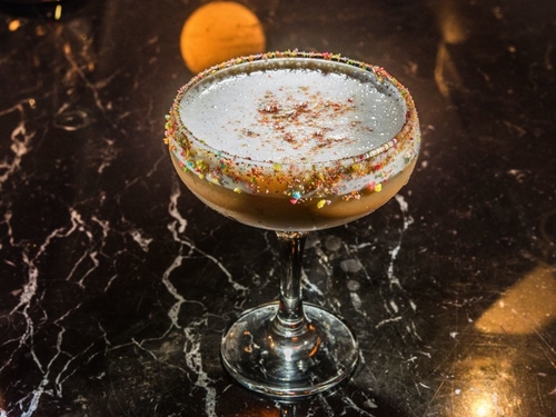 A ginger bread cocktail with rainbow flecks on the rim