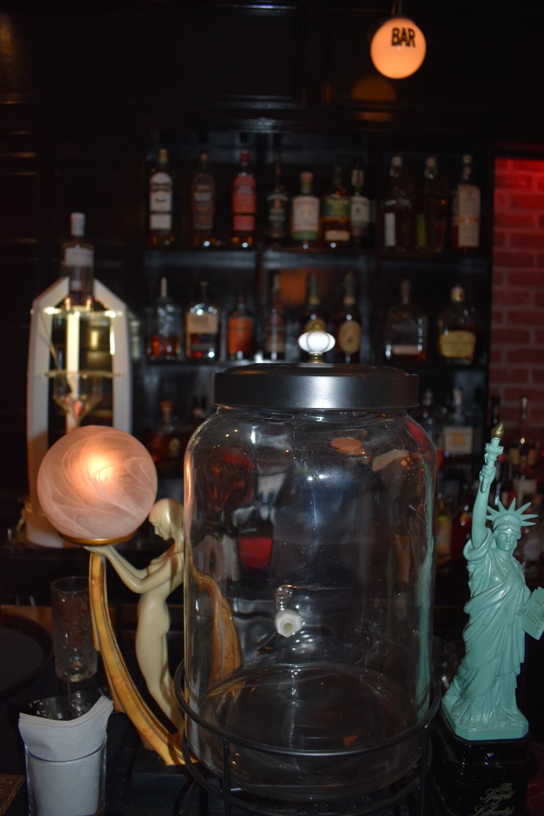 Empty glass container with a miniature statue of liberty on the right side