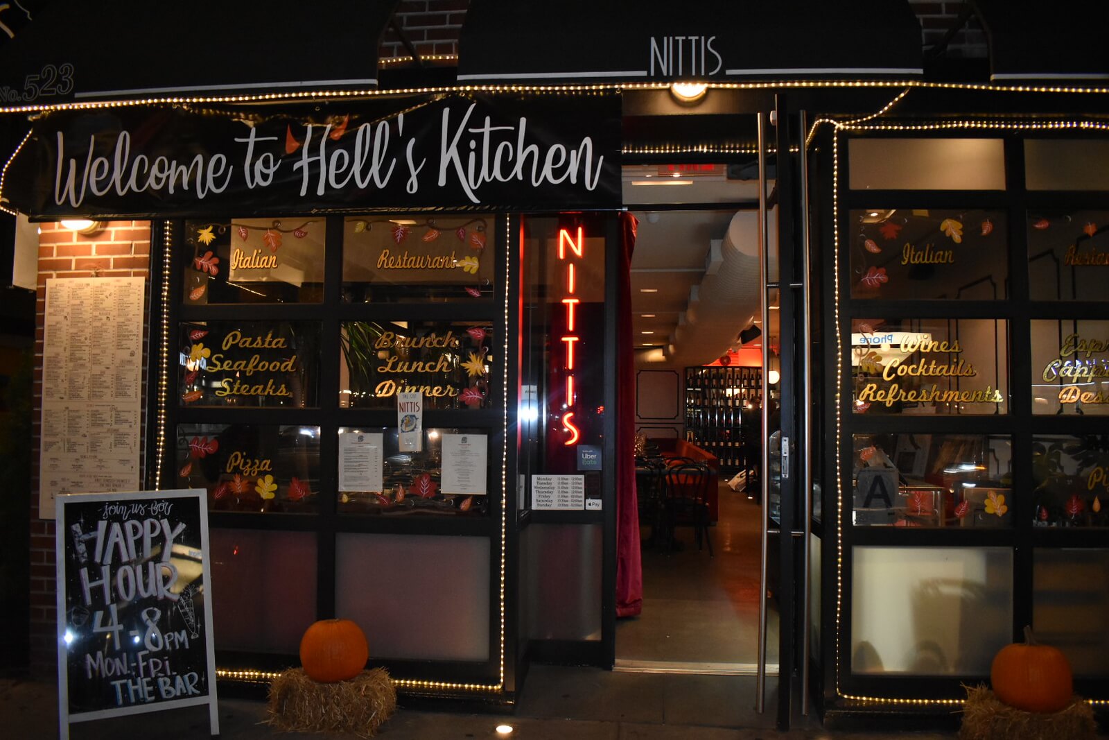 Entrance to restaurant with a 'Welcome to Hells Kitchen' banner hanging on the awning